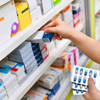 pharmacist-holding-medicine-box-and-capsule-pack-in-pharmacy-drugstore