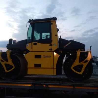 Un rullo compattatore che prepara la base granulare stabilizzata prima della stesa del bitume.